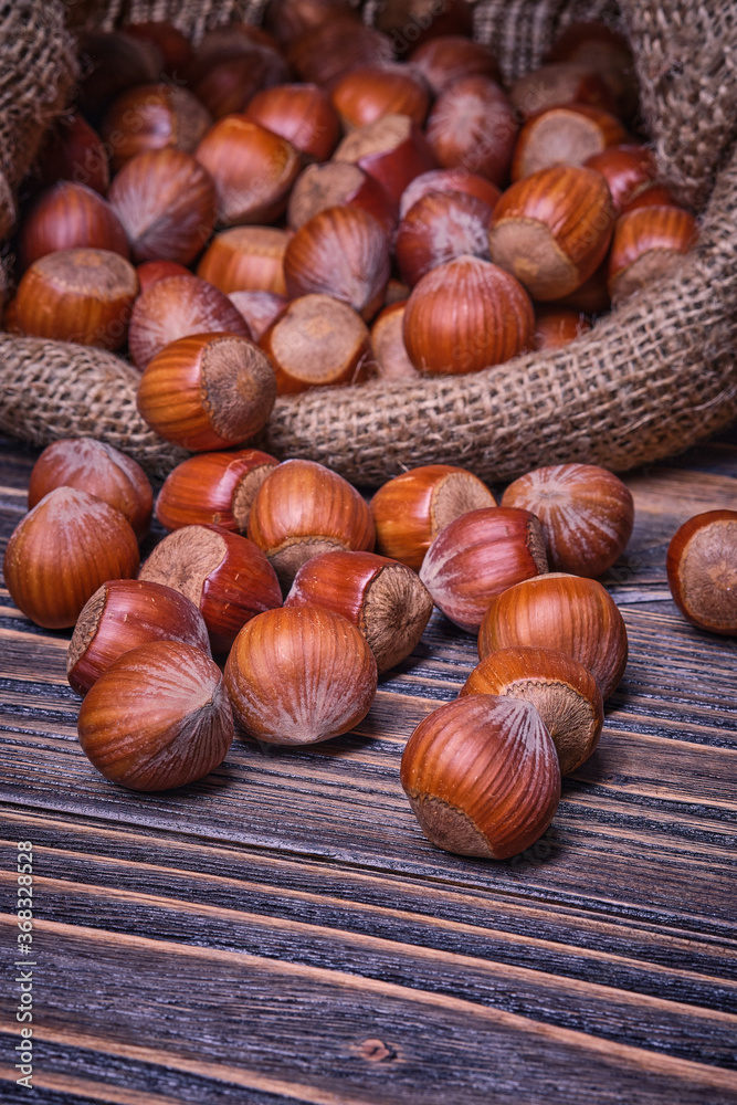 Hazelnuts in bag, vegetarian food in wooden bowls, on old wooden background Hazelnuts in bag, vegetarian food in wooden bowls, on old wooden background
