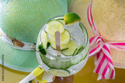 gin and tonic on glass and hats surrounding it with love and passion