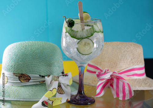 gin and tonic on glass and hats surrounding it with love