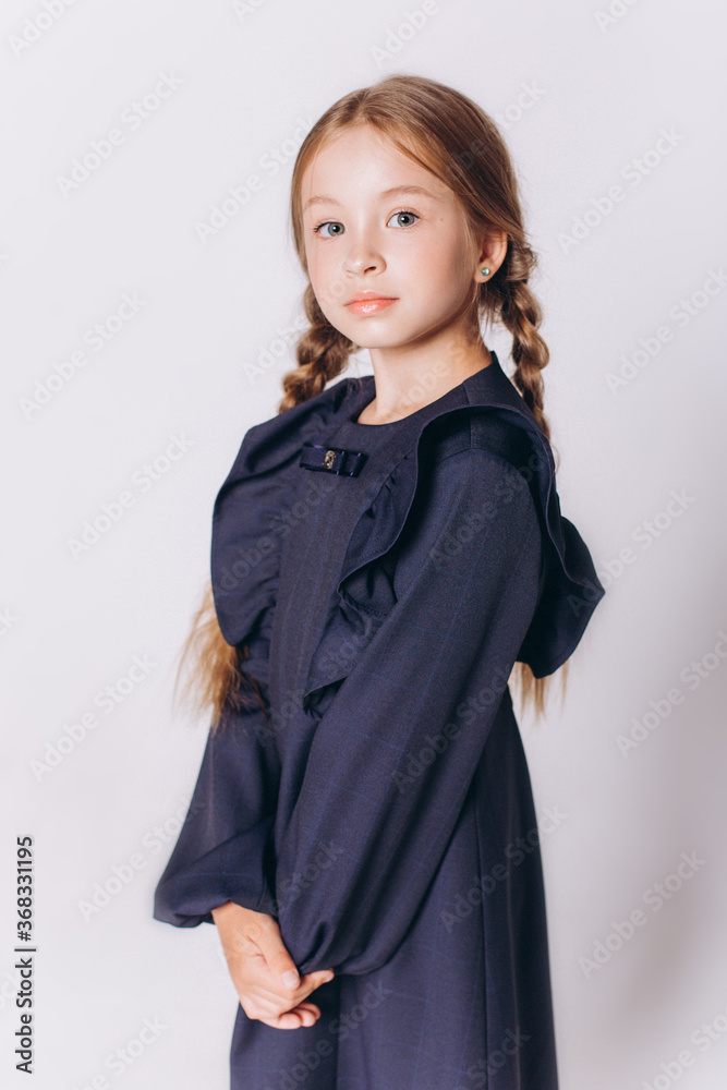 Back to school. Cute adorable caucasian blondie girl with glode in school uniform on white background Back to school. Cute adorable caucasian blondie girl with glode in school uniform on white background