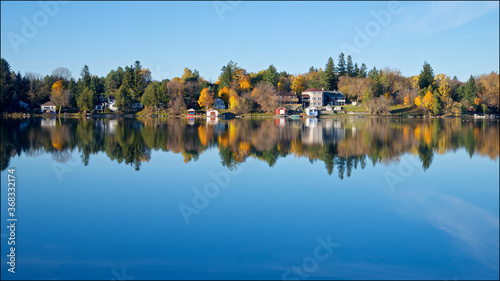Konstfotografi Reflection of the cottages and fall leaf color in the lake district, Ontario, Canada