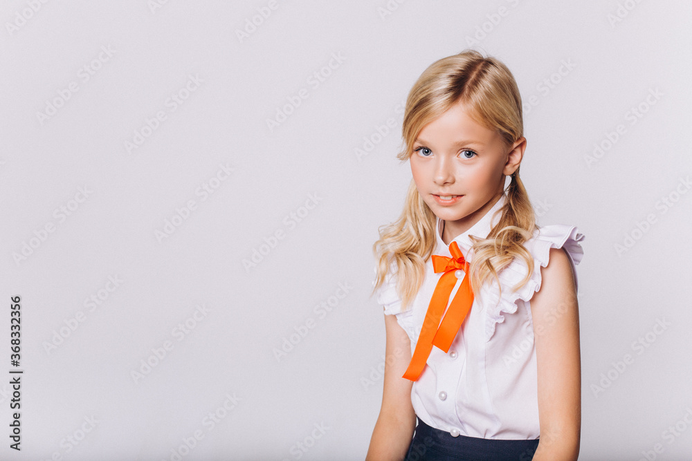 Back to school. Cute adorable caucasian blondie girl in school uniform on white background Back to school. Cute adorable caucasian blondie girl in school uniform on white background