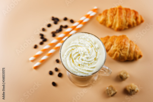 Coffee with whipped cream in a glass with coffee beans