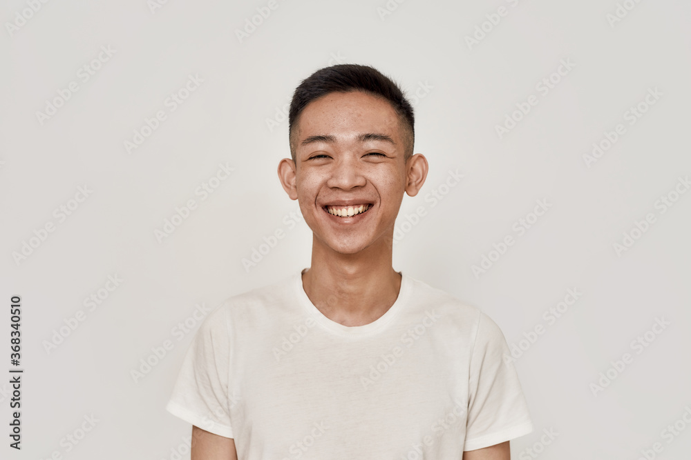 Happy guy. Portrait of young asian man with clean shaven face smiling at camera isolated over white background. Beauty, skincare, health concept