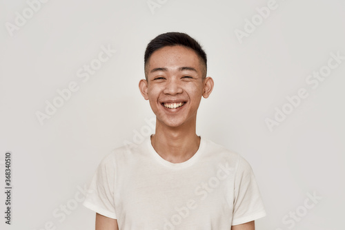 Happy guy. Portrait of young asian man with clean shaven face smiling at camera isolated over white background. Beauty, skincare, health concept