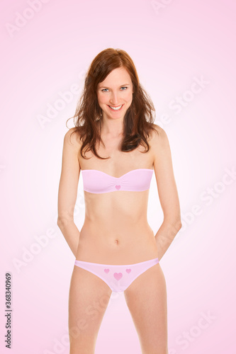 Highly attractive young woman wearing pink bra and panties, closeup portrait isolated in front of pink  background © Jochen Schönfeld