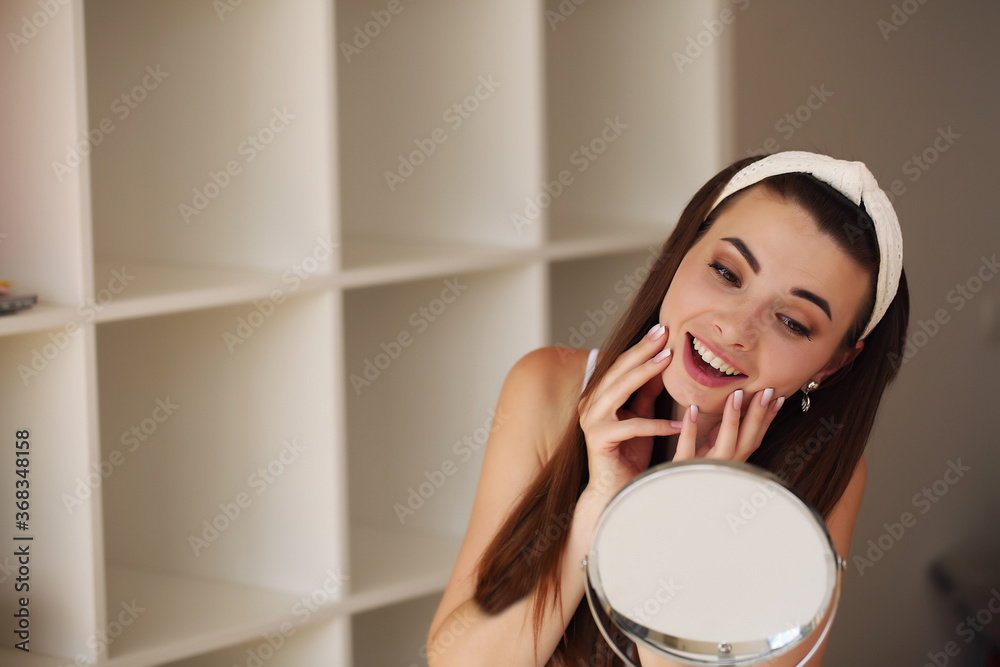sitting at home, looking in the mirror, laughing and having fun. Morning skin care regimen. sitting at home, looking in the mirror, laughing and having fun. Morning skin care regimen.