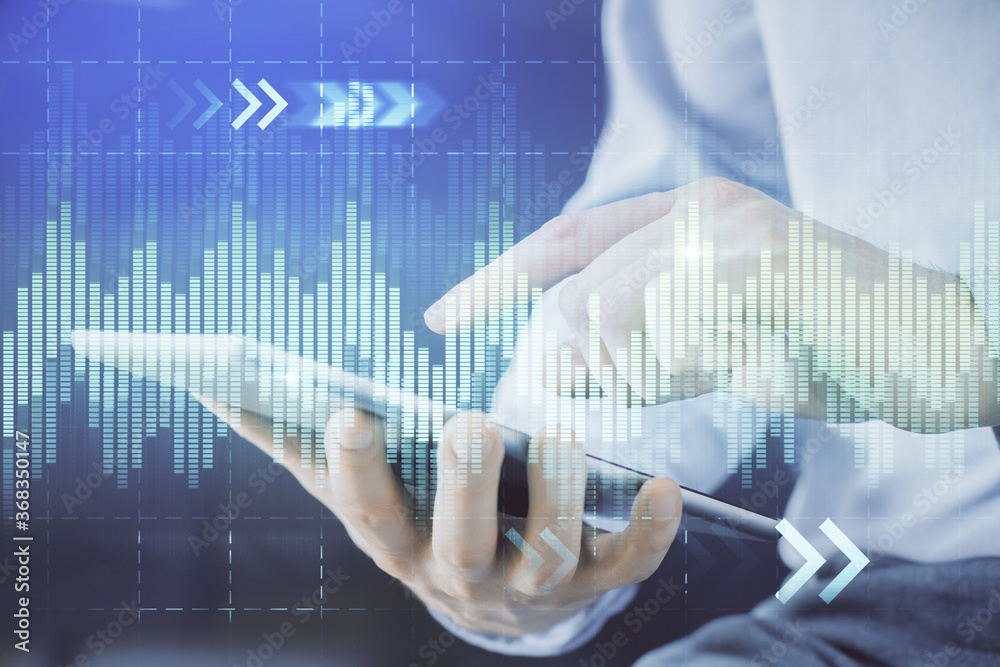 Double exposure of man's hands holding and using a digital device and forex graph drawing. Financial market concept. Double exposure of man's hands holding and using a digital device and forex graph drawing. Financial market concept.