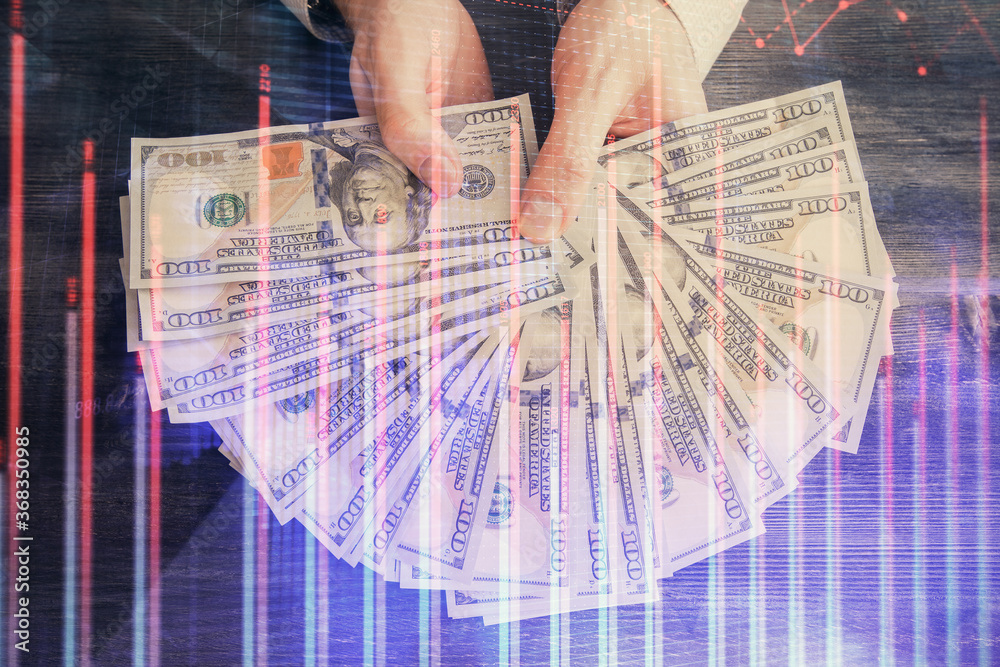 Multi exposure of financial graph drawing hologram and USA dollars bills and man hands. Analysis concept. Multi exposure of financial graph drawing hologram and USA dollars bills and man hands. Analysis concept.