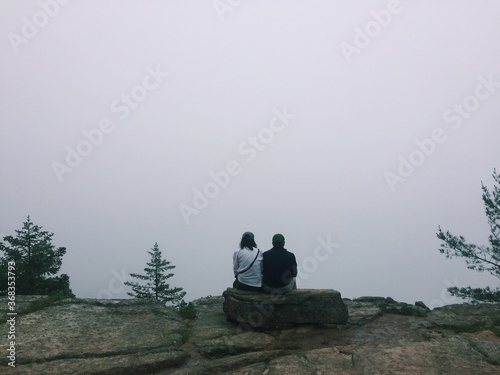 couple sitting on a rock in the mountains