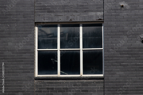 White window frame around black brick wall.