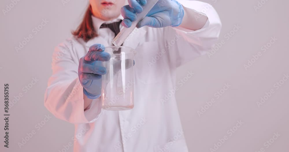 A scientist in a medical laboratory pours fluid A scientist in a medical laboratory pours fluid
