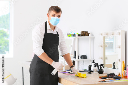 Male hairdresser cleaning w...