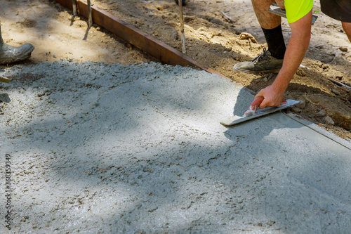 Worker plastering the concrete cement during sidewalk