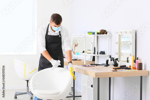 Male hairdresser cleaning w...