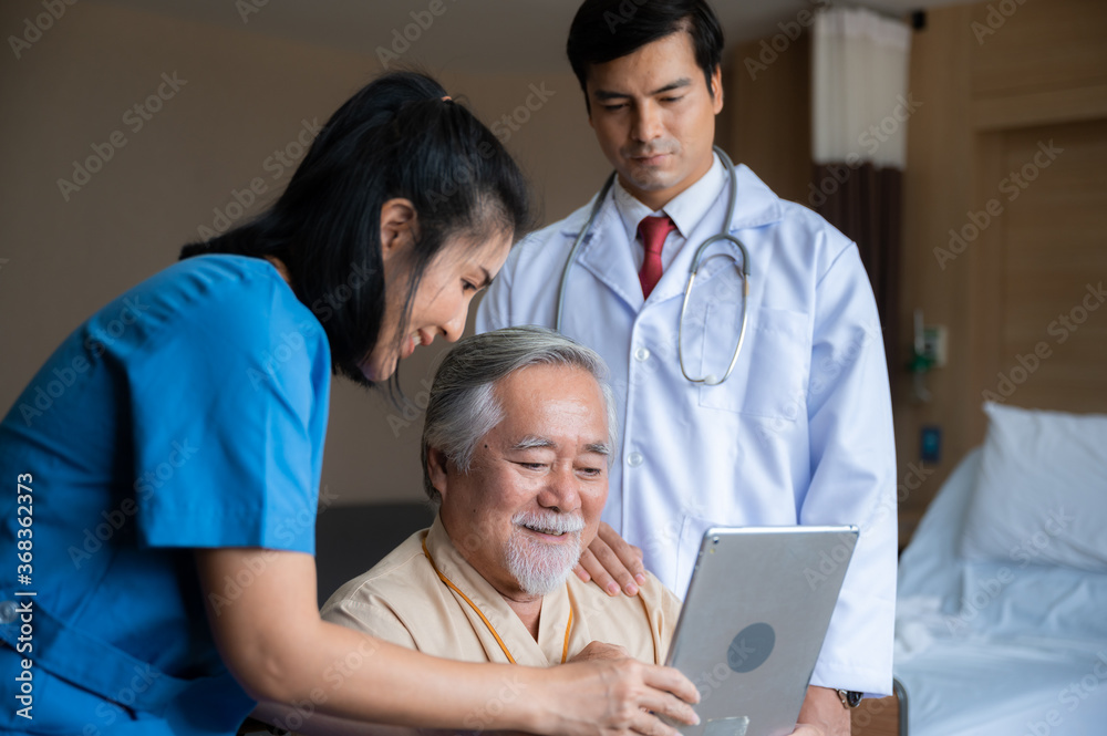 Surgeon doctor with digital tablet visiting senior male patient in hospital bed at geriatric unit Surgeon doctor with digital tablet visiting senior male patient in hospital bed at geriatric unit