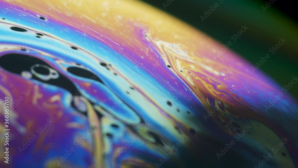 Fluid dynamics and light refraction diffraction in soap bubble surface close up