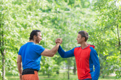 Two men after workout outdoor shake hands.