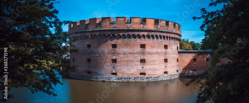 An old red brick fortress on the beach . Historical antique world.