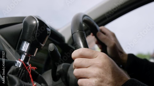 Male hands turn steering wheel in delivery van, handheld shot inside vehicle