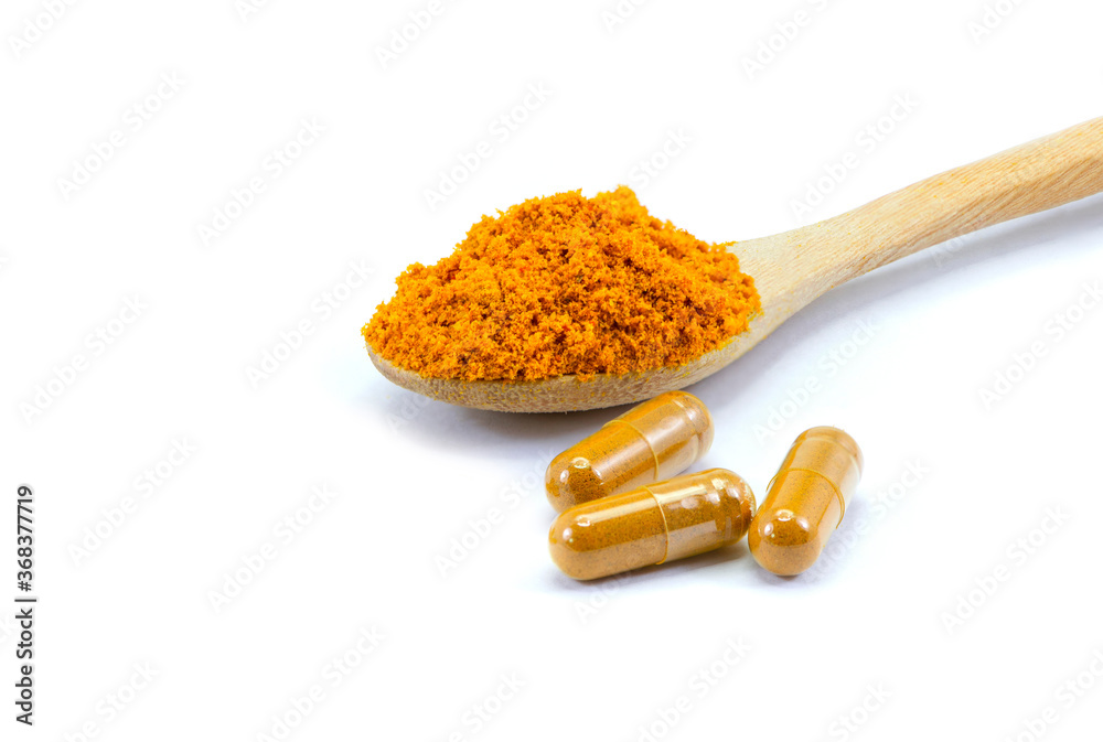Turmeric powder capsules on white.