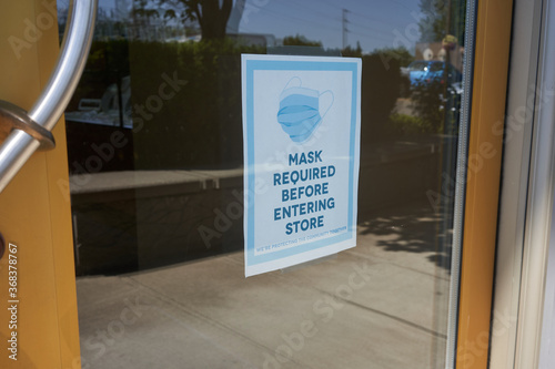 Slika na platnu Mandatory mask policy signage at the entrance to a retail store during the coronavirus pandemic