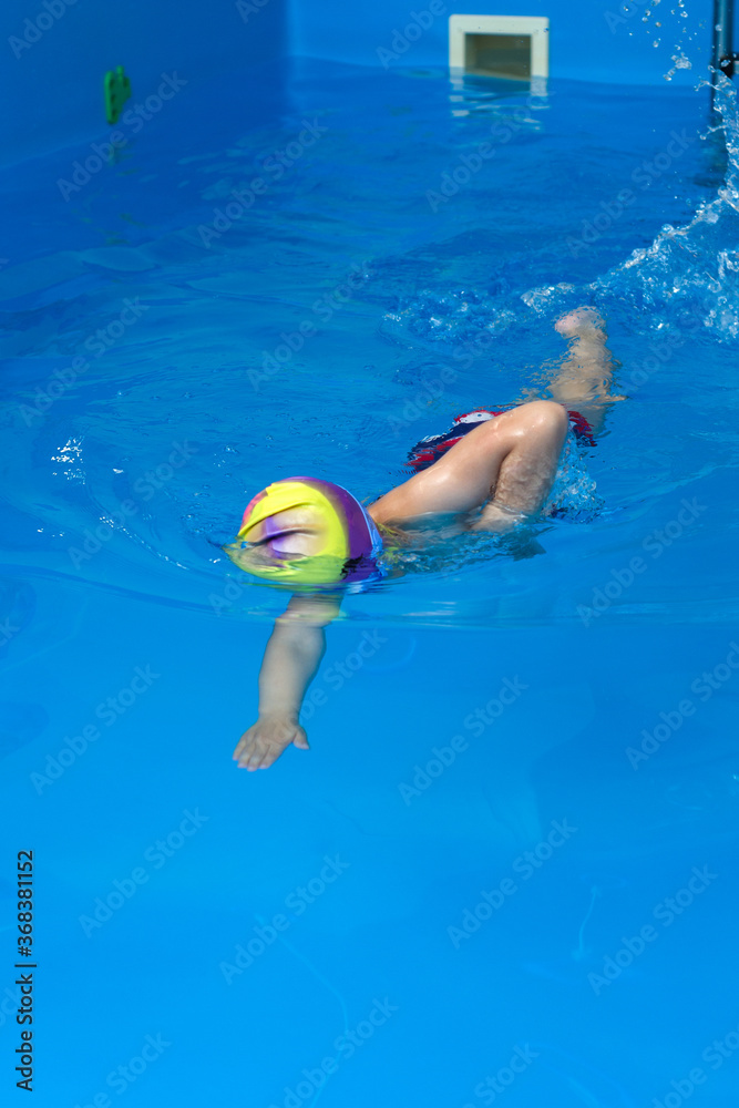 child learns to swim in the pool in the swimming section
