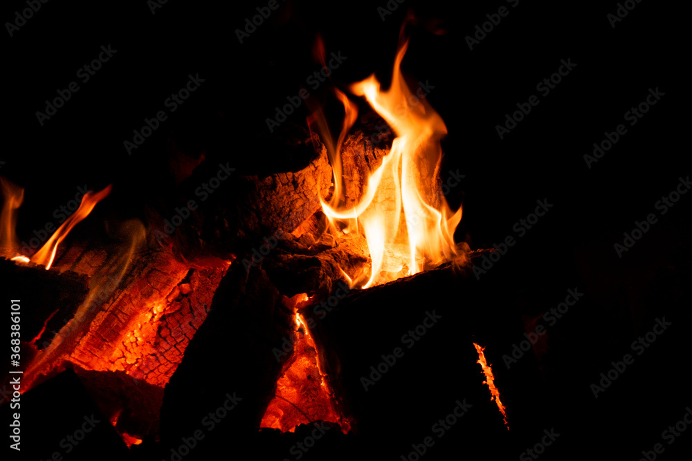 Fototapeta premium Glowing backyard campfire in a dark setting.