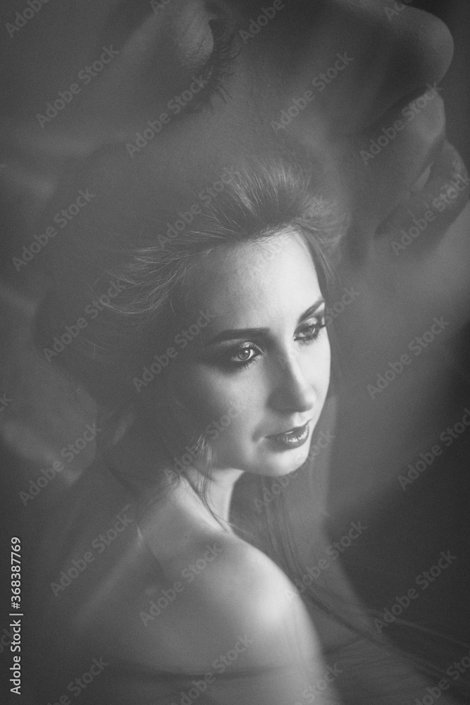 Mystical portrait of a young woman with open shoulders and hair gathered in a high hairstyle. Soul and body. double exposure	