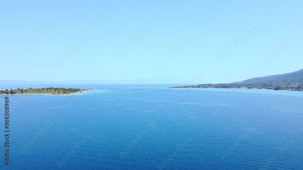 Aerial view of narrow passage between island and coast on blue sea Aerial view of narrow passage between island and coast on blue sea
