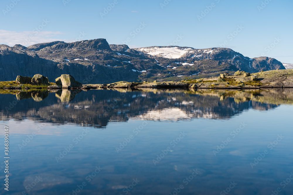 Beautiful reflection of mountains  between the way to Trolltunga cliff in Odda in a morning, western of Norway in summer season, Norway, Scandinavia