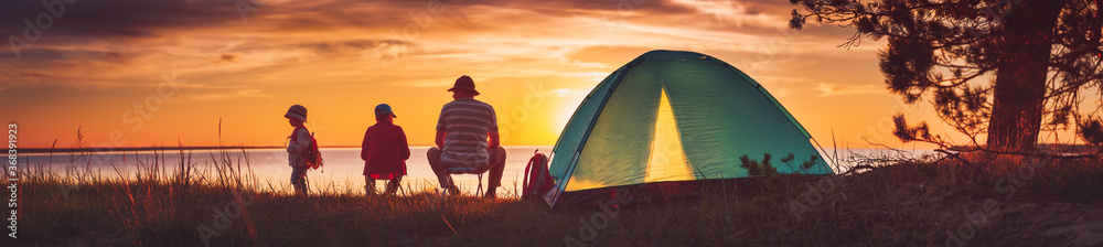 Family resting with tent in nature at sunset - obrazy, fototapety, plakaty 