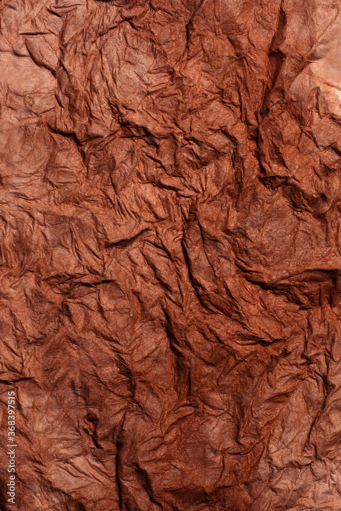 Background of raw crumpled paper. Brown recucled paper with big folds. Background of raw crumpled paper. Brown recucled paper with big folds.