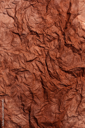 Background of raw crumpled paper. Brown recucled paper with big folds.