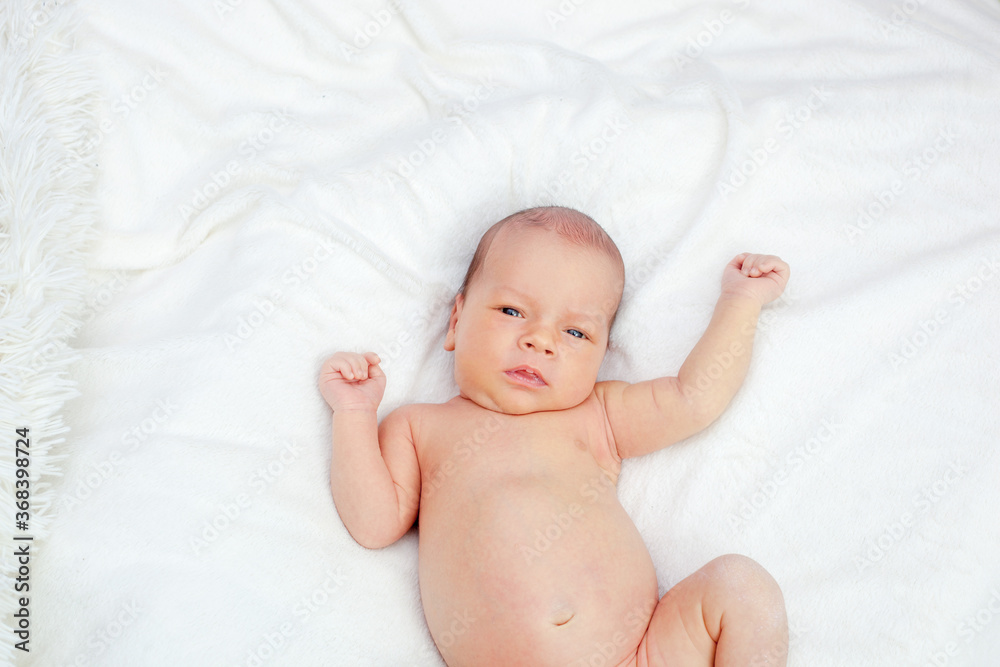 A newborn  looks directly at the camera