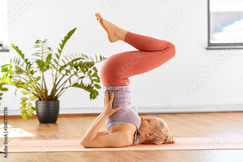 Photos fitness, people and healthy lifestyle concept - young woman doing yoga in suppor