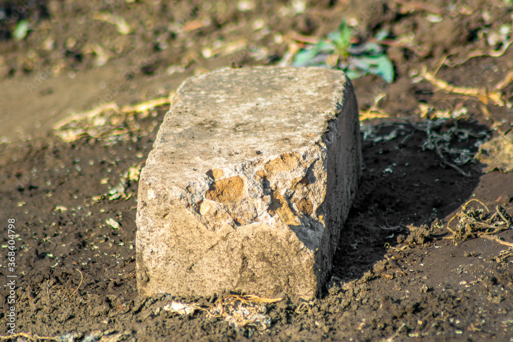 Fototapeta premium Old white brick lies on the ground, photo for design