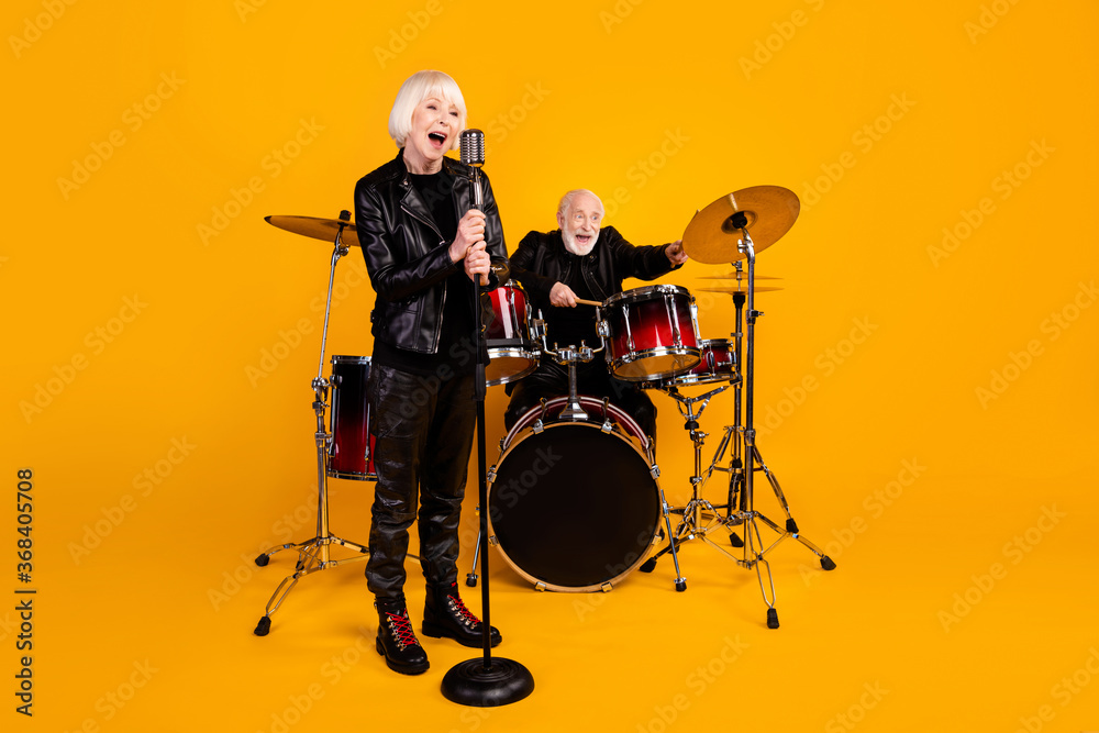 Fototapeta premium Portrait of his he her she nice attractive cheerful excited glad grey-haired couple giving live concert having fun performing isolated over bright vivid shine vibrant yellow color background