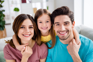 Close up photo of loving tender gentle family mother father and small kid girl cuddle hug embrace in house indoors