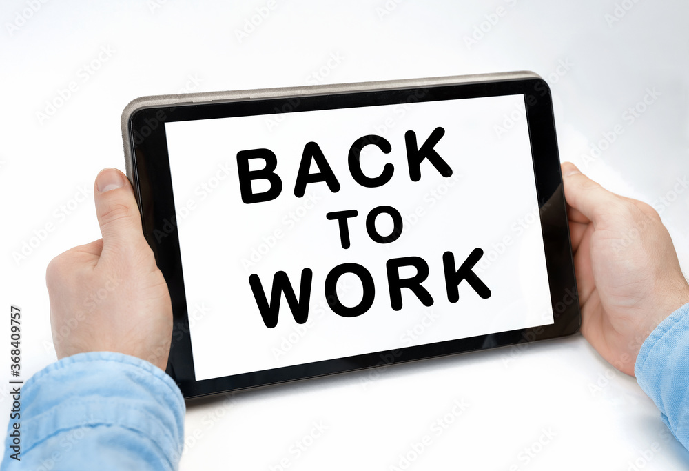 Male hands holding tablet pc with text BACK TO WORK on white background Male hands holding tablet pc with text BACK TO WORK on white background