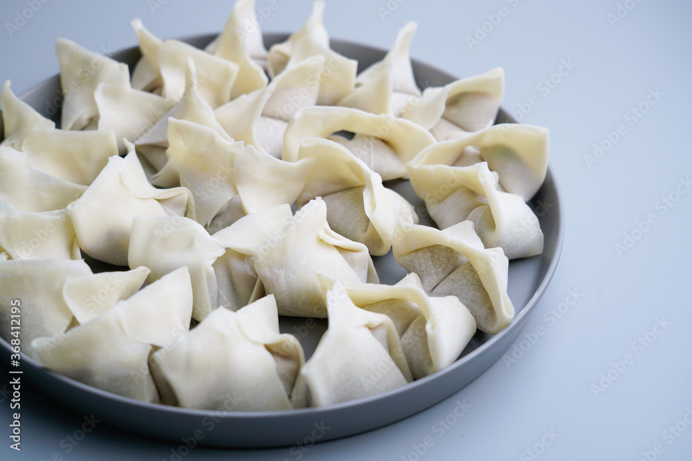Traditional Chinese food wonton is placed on agray plate. Traditional Chinese food wonton is placed on agray plate.