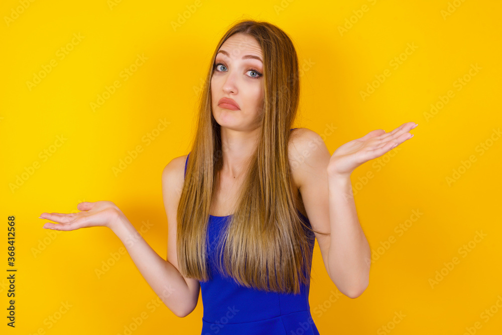 Beautiful woman doubt expression, confuse and wonder concept, uncertain future shrugging shoulders, standing against gray Wall. Beautiful woman doubt expression, confuse and wonder concept, uncertain future shrugging shoulders, standing against gray Wall.