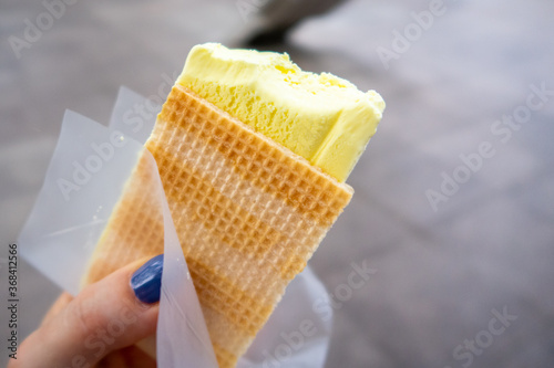 Photography Durian Ice Cream in a waffle in a woman's hand, made of Durian (Durio), asian fruit having strong, smelly odour banned in Singapore Rapid Mass Transit