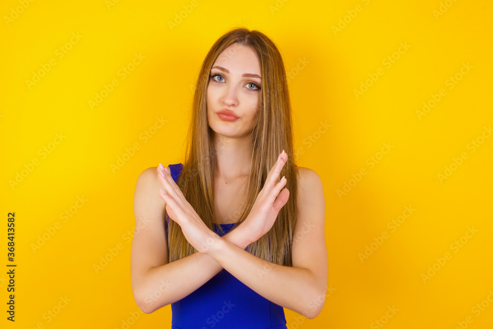 Obraz premium Young beautiful brunette girl wearing casual clothes standing over isolated background. Has rejection angry expression crossing hands doing refusal negative sign.