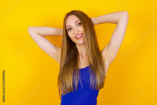 Confidence and coquettish concept. Portrait of charming young business girl, smiling broadly with self-assured expression while holding hands over her head. Standing against background.