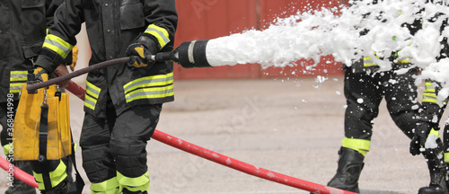 firefighter uses a foaming agent to put out a fire