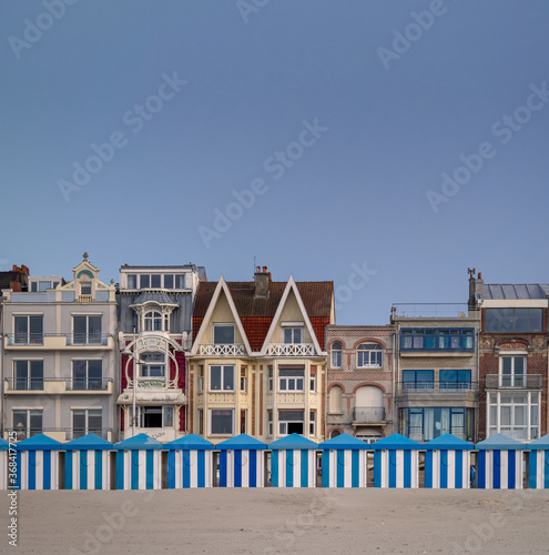Blue and white striped beach huts against evening sky