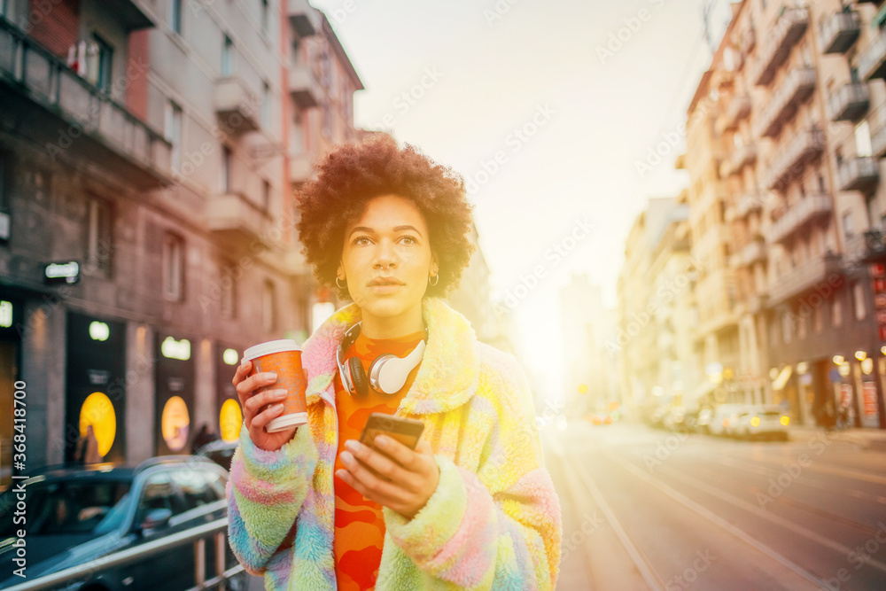 Fototapeta premium Young woman using smartphone on street