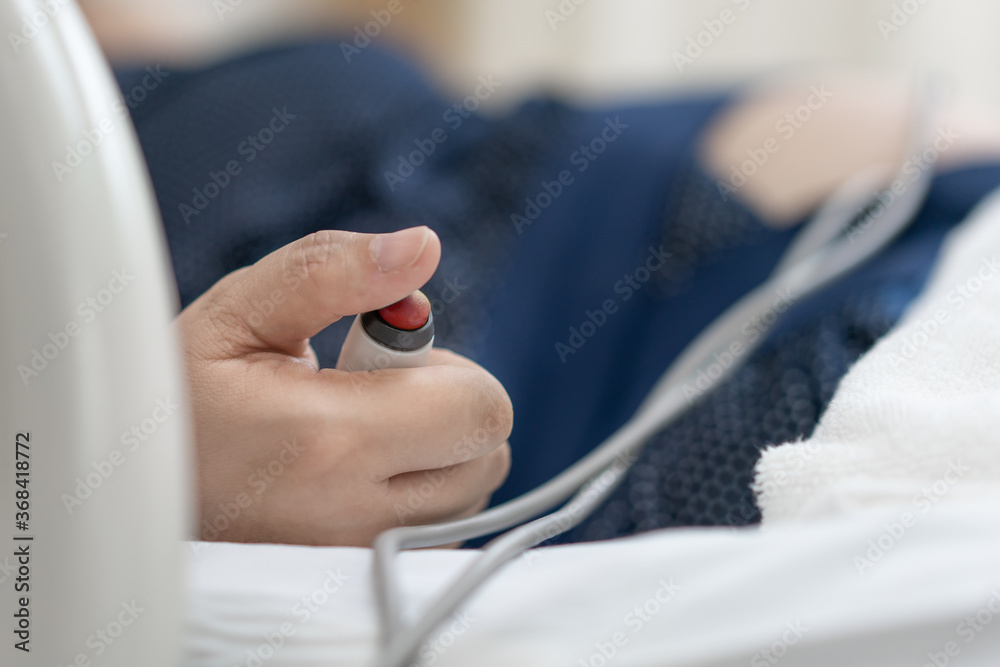 Hand pressing emergency nurse call button. Hand pressing emergency nurse call button.