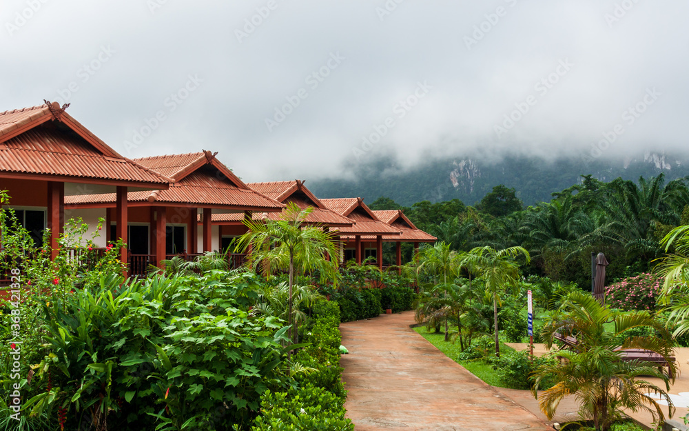 From the cabins and garden (in front) tourists have a breathtaking view to the Khao Sok jungle and nearby mountains. This morning during the rainy season, though, the dense fog is covering them.